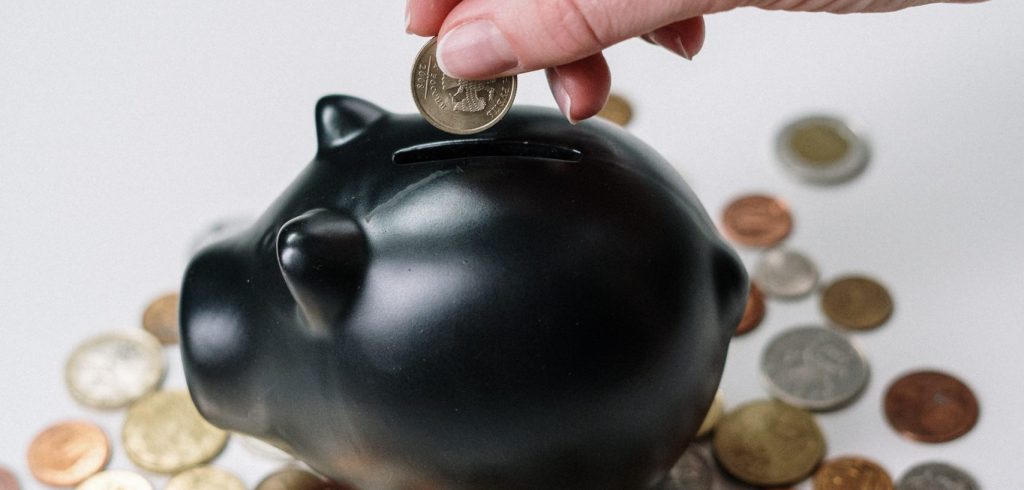 person-holding-black-ceramic-pig-coin-bank-3943723